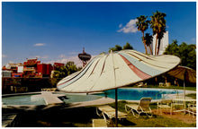 Load image into Gallery viewer, A vintage parasol, poolside at the El Morocco Motel, Las Vegas, Nevada, overlooked by palm trees, blue skies and iconic neon signs. Part of Richard Heeps&#39; &#39;Dream in Colour&#39; series.