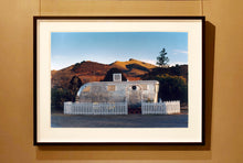 Load image into Gallery viewer, This artwork brings about a romantic dream of living in an RV. Captured in the morning sun at the start of a beautiful Arizona day, this RV is surrounded by both a white picket fence and a beautiful landscape, with the sun tickling the hilltops. Photographed as part of Richard Heeps&#39; &#39;Dream in Colour&#39; series.
