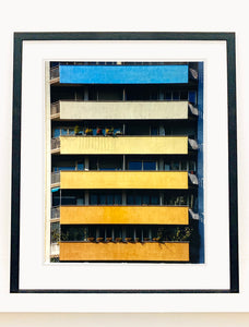 'Rainbow Apartments' captures Italian design and architecture, showing a multi-coloured nineteen-sixties block of flats. This artwork is part of Richard Heeps' series 'A Short History of Milan' which began in November 2018 for a special project featuring at the Affordable Art Fair Milan 2019, and the series is ongoing. There is a reoccurring linear, structural theme throughout the series, capturing the Milanese use of materials in design such as glass, metal, wood and stone. 