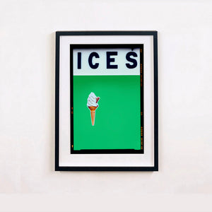 Black framed photograph by Richard Heeps.  At the top black letters spell out ICES and below is depicted a 99 icecream cone sitting left of centre against a green coloured background.  