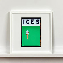 Load image into Gallery viewer, White framed photograph by Richard Heeps.  At the top black letters spell out ICES and below is depicted a 99 icecream cone sitting left of centre against a green coloured background.  