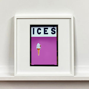 White framed photograph by Richard Heeps.  At the top black letters spell out ICES and below is depicted a 99 icecream cone sitting left of centre against plum coloured background.  