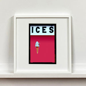 White framed photograph by Richard Heeps.  At the top black letters spell out ICES and below is depicted a 99 icecream cone sitting left of centre against a raspberry coloured background.  