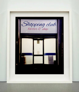 Shopping Club shows typography on a frosted glass window in Milan, Italy. 