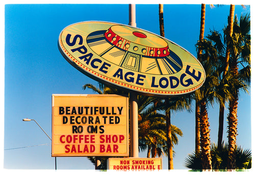 Photograph by Richard Heeps.  This retro sign takes the shape and design of a vintage UFO sign with Space Age Lodge written around the ledge of the UFO.  This is set against Arizona's palm trees and blue skies.