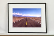 Load image into Gallery viewer, &#39;The Road to Death Valley&#39;, taken in the Majove Desert, California, features a clouded blue sky met my mountains on the horizon. This American landscape artwork is part of Richard Heeps&#39; &#39;Dream in Colour&#39; series. Taken in 2001, this artwork was first executed in Richard&#39;s darkroom in 2021.