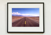 Load image into Gallery viewer, &#39;The Road to Death Valley&#39;, taken in the Majove Desert, California, features a clouded blue sky met my mountains on the horizon. This American landscape artwork is part of Richard Heeps&#39; &#39;Dream in Colour&#39; series. Taken in 2001, this artwork was first executed in Richard&#39;s darkroom in 2021.
