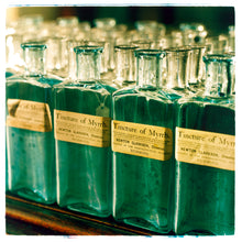 Load image into Gallery viewer, Photograph by Richard Heeps.  Rows of square green bottles labelled Tincture of Myrrh.