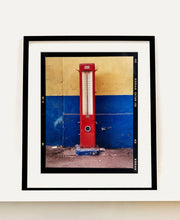 Load image into Gallery viewer, A red retro tyre pump against a yellow and blue painted wall, in the Porta Genova area of Milan. 
