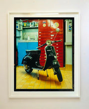 Load image into Gallery viewer, A black vespa against a red, blue and yellow interior. Photographed in Milan, Italy. 