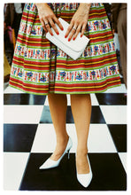 Load image into Gallery viewer, Photograph by Richard Heeps.  Vintage Goodwood, striped and patterned skirt and white stilettos. White clutch bag held as a centre piece. 