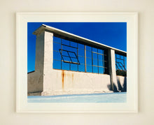Load image into Gallery viewer, &#39;Window of the World, Zzyzx Resort Pool&#39;, photographed in Soda Dry Lake, California shows window pains and a distressed wall, against a bright blue background of sky. This artwork is part of Richard&#39;s &#39;Dream in Colour&#39; series. 