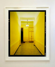 Load image into Gallery viewer, A yellow glow fills the corridor of an apartment foyer in Milan.